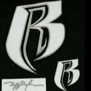 May include: Black background with two white stylized letter "B" designs, one large and one small. The letters have a silver outline. A small rectangular label with a signature is below the larger letter.