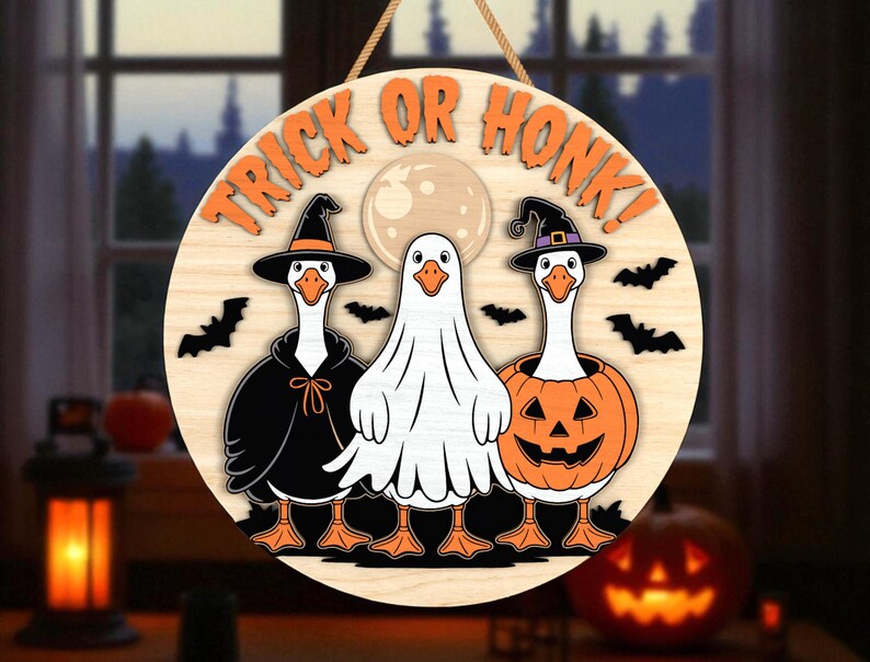 May include: Round wooden Halloween sign with the text "TRICK OR HONK!" featuring three geese in costumes: a witch, a ghost, and a jack-o'-lantern. Bats and a full moon are also included in the design. The sign is hanging by a rope.
