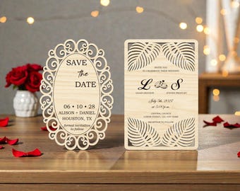 May include: Two wooden wedding invitations. One is oval-shaped with the text "Save the Date" and wedding details. The other is rectangular with leaf cutouts and wedding details, including names and date.
