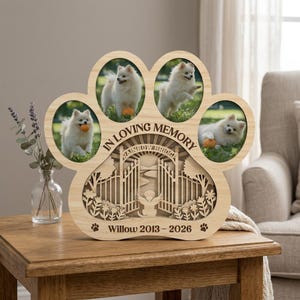 May include: Wooden paw-shaped photo frame with four circular openings, each holding a photo of a small, fluffy white dog. The frame includes the text "IN LOVING MEMORY" and "Rainbow Bridge", plus the name "Willow 2013-2026".
