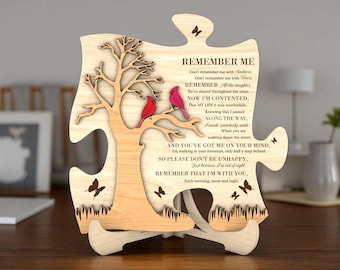 May include: Wooden puzzle piece with a tree and two red cardinals. The puzzle has the words "REMEMBER ME" and a poem. Butterflies are cut out of the wood. The piece is displayed on a wooden stand.