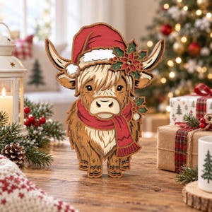May include: A layered wooden cutout of a Highland cow wearing a red Santa hat and a red scarf. The cow features light brown fur, dark brown accents, and a decorative holly sprig with red berries on its head. The design is multi-dimensional.