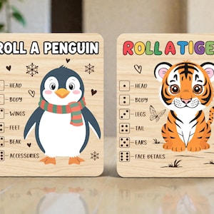 May include: Two wooden game boards with cartoon animal illustrations. One board says "Roll a Penguin" and features a penguin with a scarf. The other says "Roll a Tiger" and features a tiger. Each board has dice and body part labels.