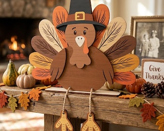 May include: A wooden turkey decoration featuring a brown body, a black pilgrim hat with a yellow buckle, and a fan of colorful feathers in shades of orange, brown, and cream. The turkey has dangling rope legs with yellow feet and sits on a base.