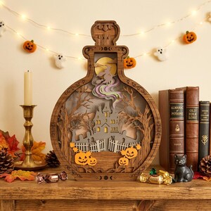 May include: A wooden potion bottle-shaped display featuring a layered cutout scene of a haunted house, a witch on a broomstick, and orange jack-o'-lanterns. The frame is decorated with moon phases and intricate carvings, creating a dimensional effect.