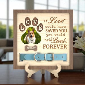 May include: Wooden framed pet memorial with a photo of a dog, paw print design, and the text "If Love could have SAVED YOU you would have Lived FOREVER." Includes a light blue dog collar. The dog's name, "Shelby," is on a bone-shaped tag.