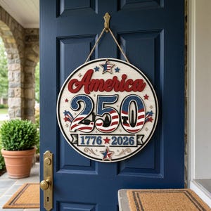 May include: A round wooden sign with the text "America 250" in red, white, and blue. The sign includes the years "1776-2026" and star and stripe designs. It hangs from a natural rope against a blue door.