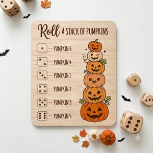Könnte beinhalten: Ein rechteckiges Spielbrett aus Holz mit dem Text Roll A Stack Of Pumpkins. Das Brett zeigt eine Liste von Würfelseiten, die mit Kürbisbeschriftungen gepaart sind, sowie eine vertikale Illustration von sechs gestapelten Kürbissen in Orange und Creme.