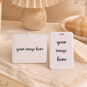 May include: Two white rectangular badge holders made of smooth material. One holder is oriented horizontally with a metal ring at the top, and the other is oriented vertically with a slot. Both feature the black printed text your image here.