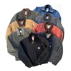 May include: A collection of work jackets in various colors, including black, brown, green, and blue. Each jacket features a corduroy collar, a zipper closure, and a small square logo on the front. The jackets are arranged in a circular pattern.