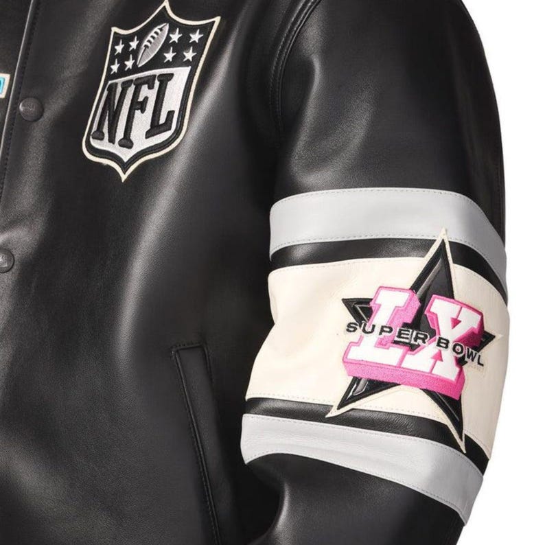 Pu&ograve; includere: Giacca in pelle nera con la toppa del logo NFL sul petto. La manica presenta una toppa Super Bowl LX con un design a stella, dettagli bianchi, grigi e rosa. La giacca ha un classico stile college.