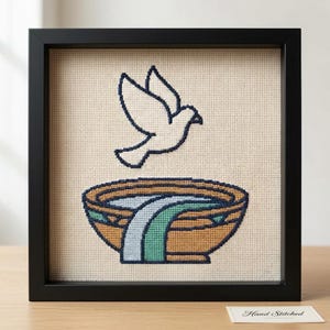 Può includere: Un ricamo a punto croce incorniciato su tela Aida beige che presenta il contorno blu scuro di un uccello in volo sopra una ciotola color cuoio con un panno azzurro e verde drappeggiato sul bordo. L'opera è racchiusa in una cornice nera.