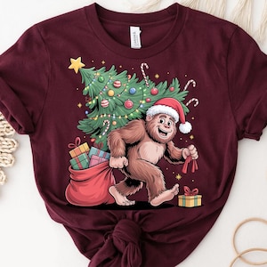 Christmas Bigfoot Shirt – Funny Sasquatch Tree Gift Tee – Bigfoot Santa T-Shirt – Holiday Yeti Graphic Shirt – Cute Xmas Cryptid Tee
