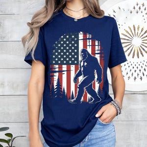American Flag Bigfoot Shirt – Patriotic Sasquatch Tee – USA Forest Cryptid Graphic – 4th of July Hiking T-Shirt – Bigfoot Lover Gift Idea