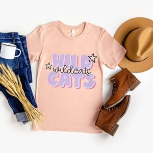 Camiseta de los Wildcats en tonos pastel, bonita camiseta con espíritu escolar, genial camiseta de los Wildcats para el día del partido, camiseta rosa y morada de porristas, camiseta con estampado de mascota retro