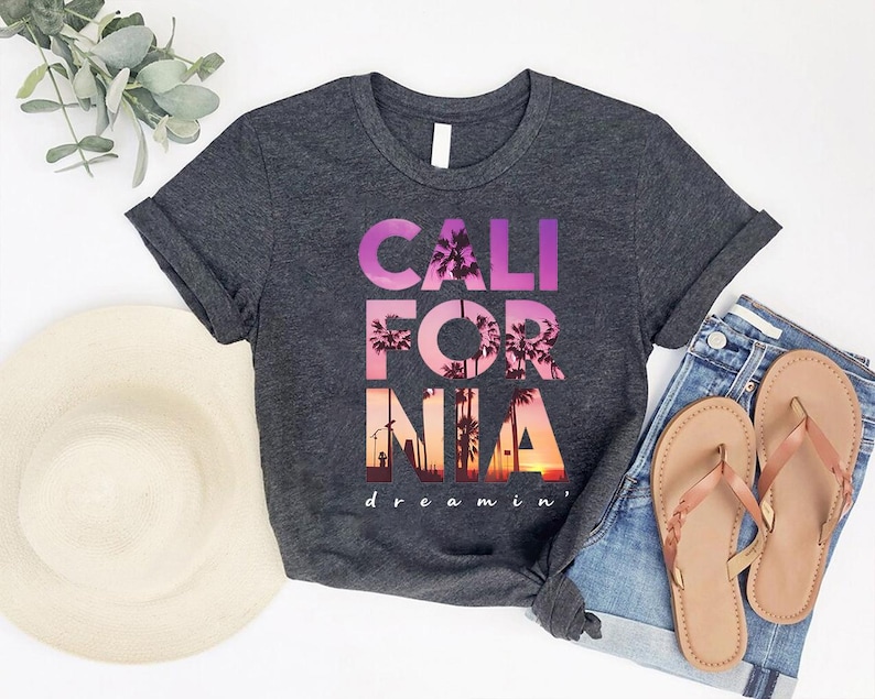 a gray t-shirt with the text "CALIFORNIA dreamin'" printed on it, along with a pair of jeans and a hat.