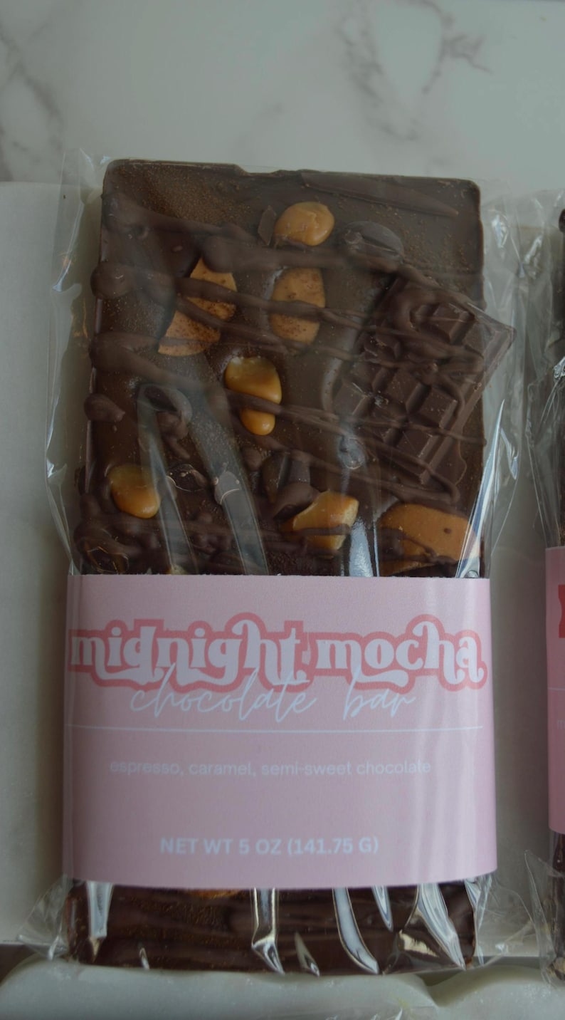 Peut inclure: Une barre de chocolat noir avec des morceaux de caramel et des morceaux de chocolat, emball&eacute;e dans du plastique transparent. La barre est &eacute;tiquet&eacute;e "midnight mocha chocolate bar" avec les ingr&eacute;dients espresso, caramel et chocolat mi-sucr&eacute;. Poids net 141,75 g.