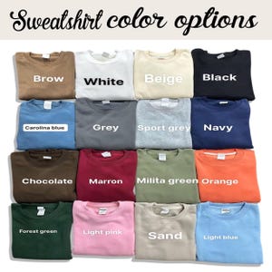May include: Image showcasing a variety of sweatshirt color options. Colors include Brow, White, Beige, Black, Carolina Blue, Grey, Sport Grey, Navy, Chocolate, Marron, Milita Green, Orange, Forest Green, Light Pink, Sand, and Light Blue. The text "Sweatshirt color options" is at the top.