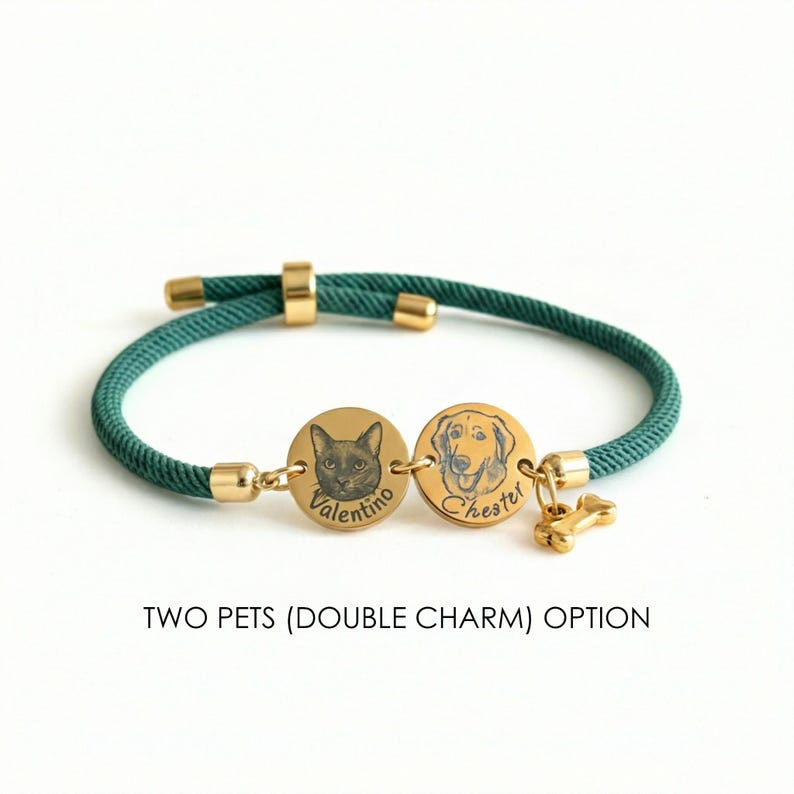 May include: A dark green cord bracelet featuring two gold-toned circular charms engraved with pet portraits and the names Valentino and Chester, accompanied by a small gold-toned bone charm. The text TWO PETS (DOUBLE CHARM) OPTION is visible.