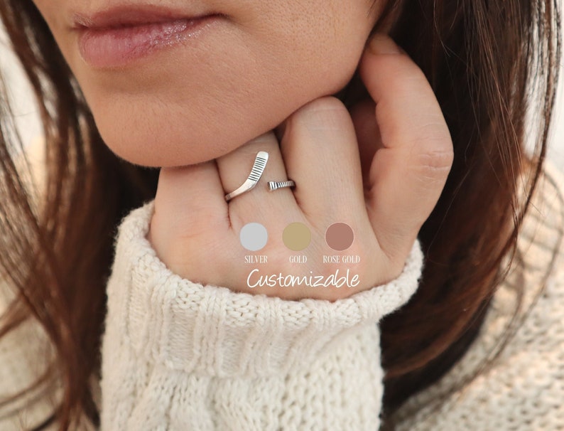 May include: A silver hockey stick ring with a customizable option for gold or rose gold.