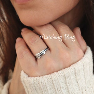 May include: A silver ring with a leaf design. The ring is worn on a person's finger. The text "Matching Ring" is written on the image.
