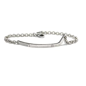 Op de afbeelding: Een zilveren armband met een staafvormig middelpunt en een schakelketting. De staaf heeft ge&euml;tste lijnen en rechthoekige details. De armband wordt op een witte achtergrond getoond.