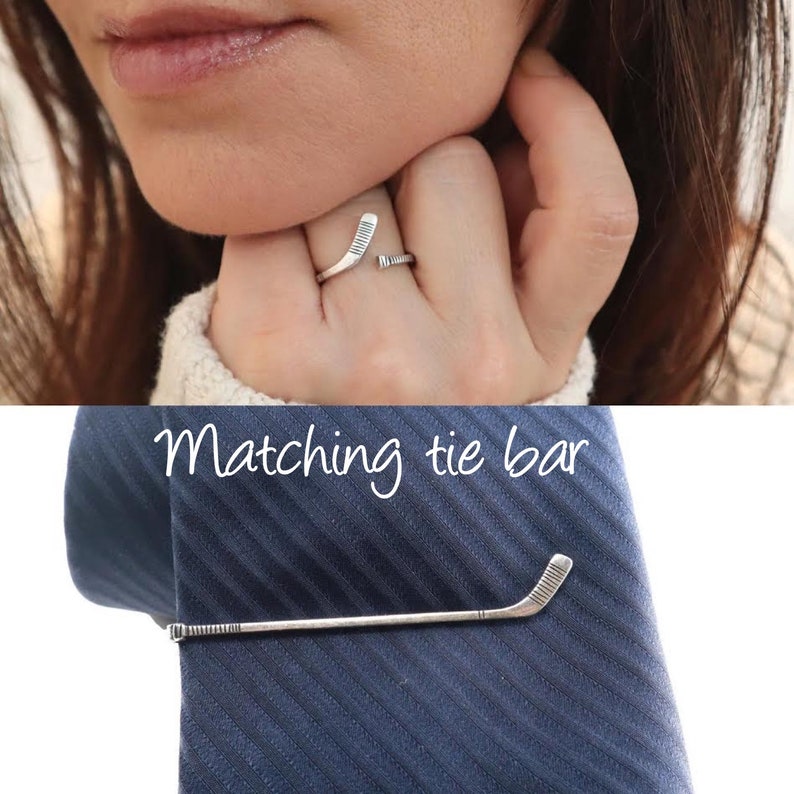 May include: A silver ring and matching tie bar featuring a hockey stick design. "Matching tie bar" is written in white text on a blue background.