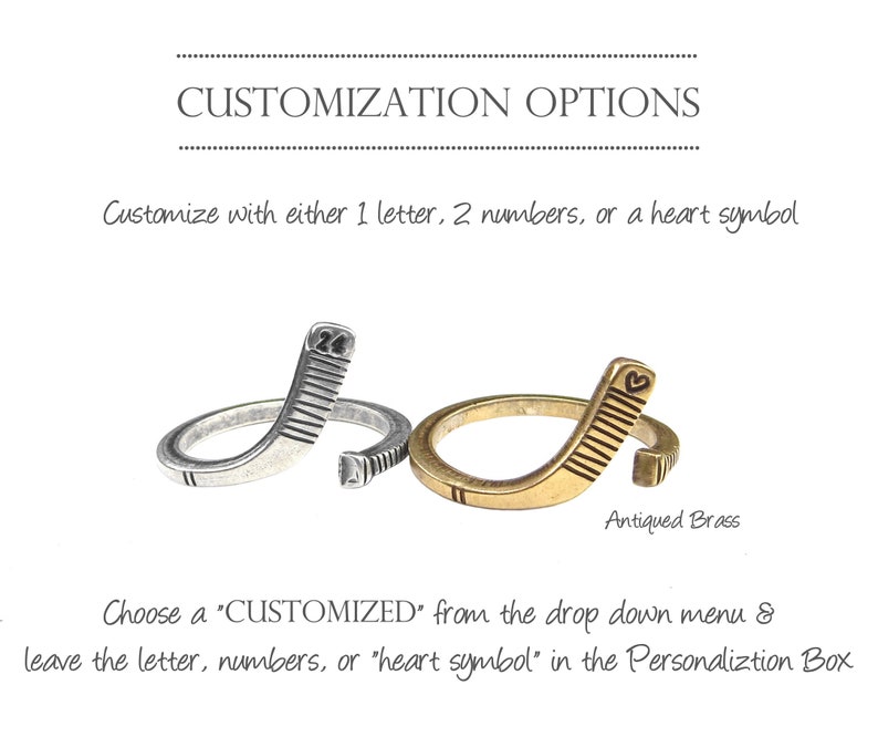May include: Two hockey stick rings, one silver and one antique brass. The silver ring has the number "24" engraved on it. The brass ring has a heart symbol engraved on it. Customize with a letter, numbers, or a heart symbol.