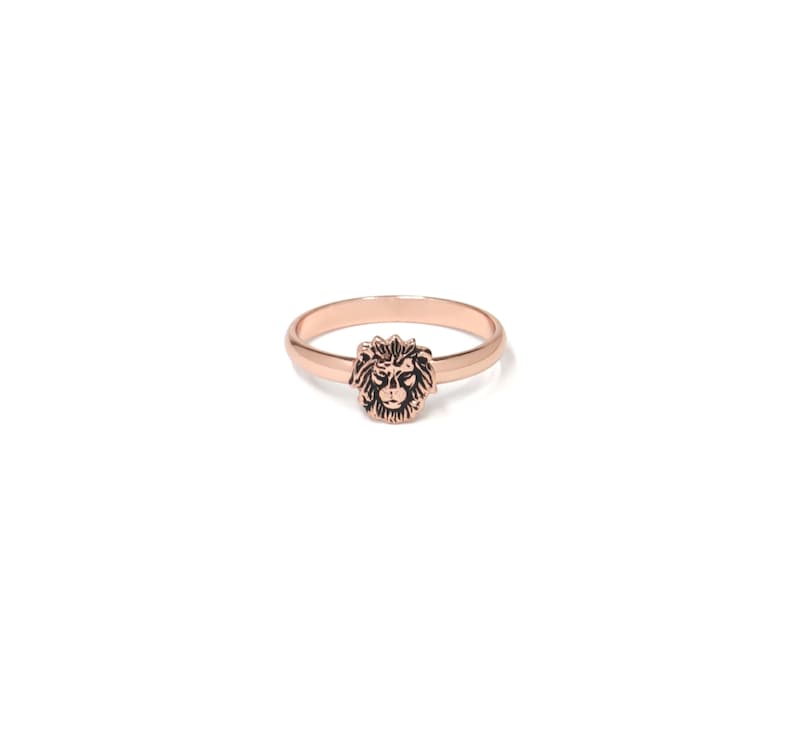 May include: A rose gold ring with a lion head design.