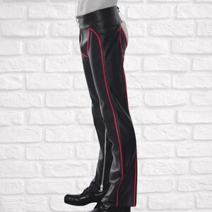 May include: Black leather pants with red stitching and a zipper detail on the side seams.
