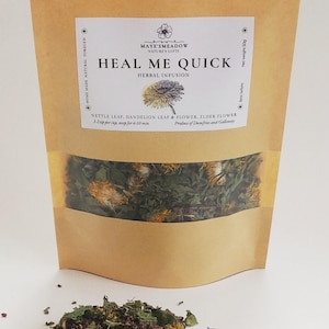 Könnte beinhalten: Ein brauner Papierbeutel mit einem Etikett, auf dem "Heal Me Quick Herbal Infusion" steht und die Zutaten Brennnesselblatt, Löwenzahnblatt & -blüte und Holunderblüte aufgelistet sind. Der Beutel enthält eine Mischung aus getrockneten Kräutern, darunter grüne Blätter, gelbe Blüten und violette Blütenknospen.