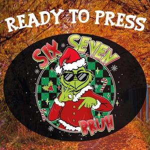 Peut inclure: Un motif ovale noir avec le texte "READY TO PRESS" en haut. Le motif présente un personnage de dessin animé vert portant un bonnet de Père Noël et des lunettes de soleil, avec les mots "SIX SEVEN BRUH". L'arrière-plan est une scène de feuillage d'automne.