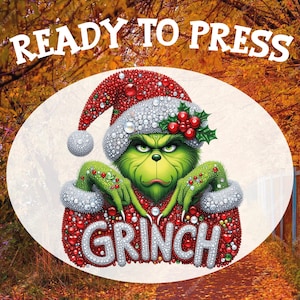 May include: A green Grinch character wearing a Santa hat and a red and white outfit. The word "GRINCH" is displayed in silver letters. The text "READY TO PRESS" is at the top of the image. The background is an autumn scene.