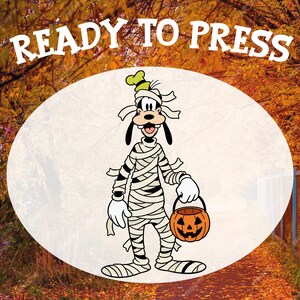 May include: A cartoon image of Goofy dressed as a mummy, holding a jack-o'-lantern. The text "READY TO PRESS" is at the top. The background is an autumn scene with fall foliage.