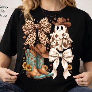 May include: A black t-shirt featuring a graphic print of a leopard print bow, a ghost wearing a brown cowboy hat and holding a lasso, a pair of turquoise and brown cowboy boots with sunflowers, and a solid cream-colored bow with small stars.