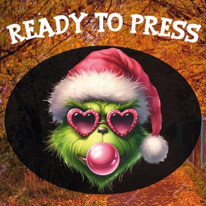 May include: A green cartoon character wearing a Santa hat and heart-shaped sunglasses, blowing a pink bubble. The image is set against a blurred background of autumn foliage and includes the text "READY TO PRESS" in white.