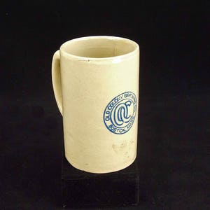 May include: A white ceramic beer mug with a blue logo that reads "Old Colony Brewing Co. Boston, Mass."