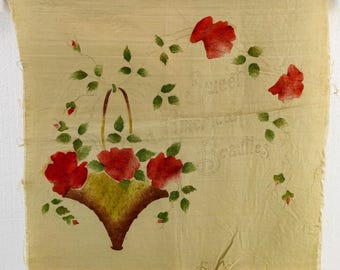 May include: A vintage fabric panel featuring a hand-painted design. A basket of red roses is the focal point, surrounded by green leaves and stems. The words "Sweet American Beauties" are written in cursive script, adding a nostalgic touch to the artwork.