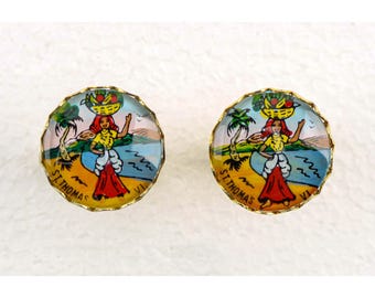 May include: Two round, gold-toned earrings with a colorful illustration of a woman carrying a basket of fruit on her head. The image includes palm trees, a beach scene, and the text "ST. THOMAS VI."