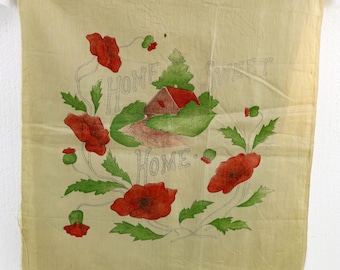 May include: A vintage fabric panel with a hand-painted design. The artwork features a red-roofed house, green foliage, and red poppies. The words "HOME SWEET HOME" are written in a script font. The panel is a light beige color.
