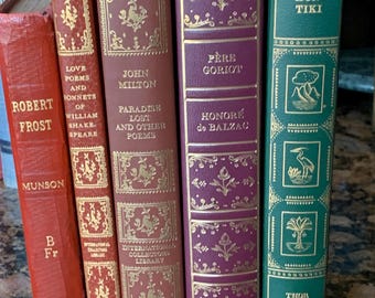 May include: A collection of five hardcover books with gold-embossed spines. The titles include Robert Frost, Love Poems and Sonnets of William Shakespeare, John Milton's Paradise Lost, Père Goriot by Honoré de Balzac, and Kon-Tiki by Thor Heyerdahl.