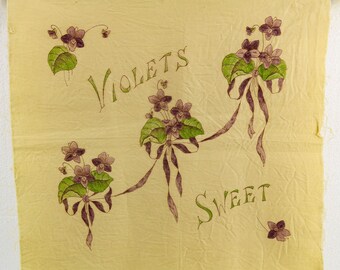 May include: A vintage yellow textile with hand-painted violets and the words "VIOLETS SWEET" in green and brown. The design features clusters of purple flowers with green leaves and brown ribbons.