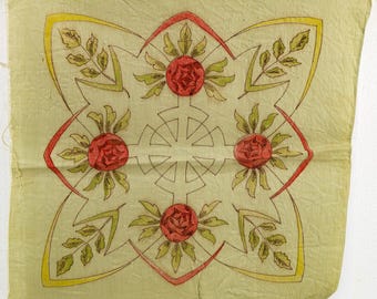 May include: A square, light green fabric with a floral design. The design features four red roses, green leaves, and yellow and red outlines. The fabric appears to be vintage or antique, with a slightly worn texture.