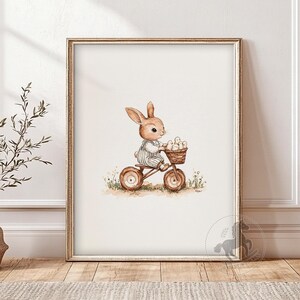 May include: A watercolor illustration of a brown bunny riding a tricycle with a basket full of chicks. The bunny is wearing a blue and white striped outfit. The background is a light beige with green grass and flowers.