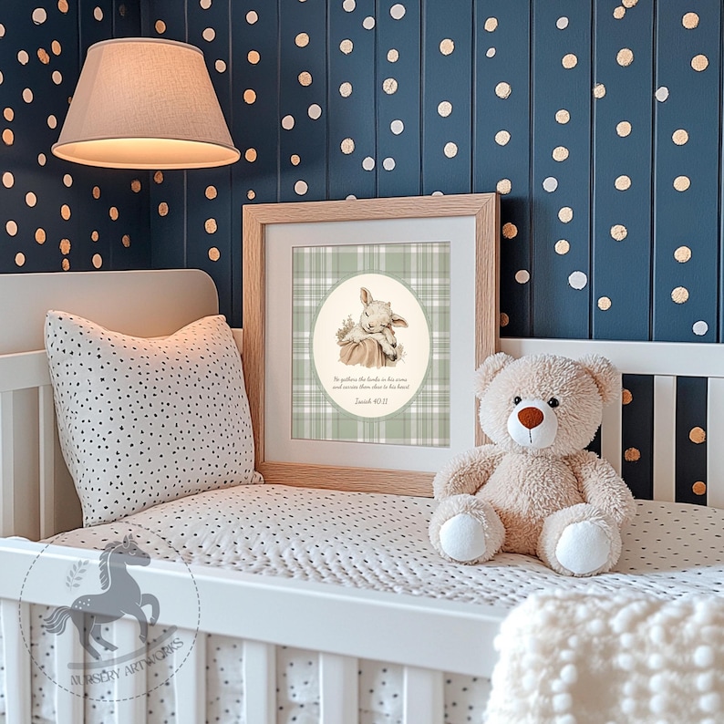 May include: A framed print featuring a lamb illustration on a green plaid background, with text from Isaiah 40:11. The print is in a nursery setting, alongside a teddy bear and a dotted pillow.