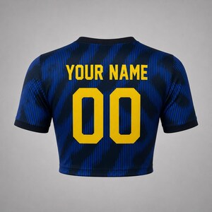 Back product mockup of a navy and blue Brazil-inspired football crop top with custom name and yellow number 00.