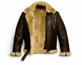 Può includere: Giacca in pelle marrone con fodera e colletto in montone beige. La giacca presenta una chiusura con zip, una cintura con fibbia in vita e finiture in montone sui polsini. Un capo di abbigliamento classico.