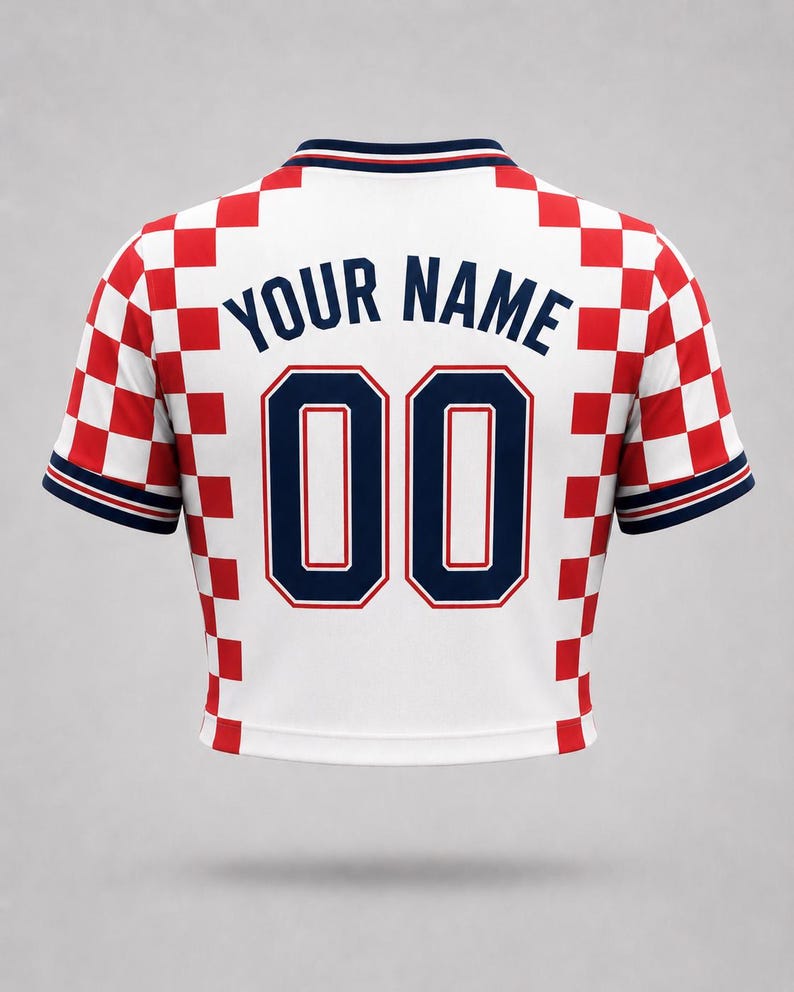 White jersey with a red and white chequered pattern on the shoulders and sleeves. The back displays the text "YOUR NAME" above the number "00" in navy blue.
