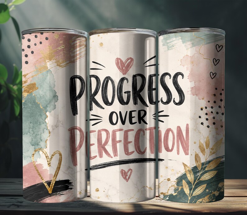 May include: A cylindrical tumbler featuring a white marble background with abstract watercolor splashes in pink, teal, and gold. The text "PROGRESS OVER PERFECTION" is printed in black and pink, accented by small hand-drawn hearts and gold leaf motifs.