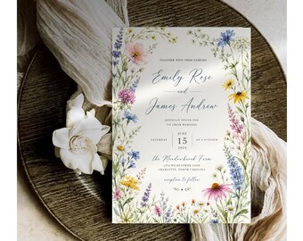 May include: A rectangular wedding invitation card featuring a watercolor floral border with blue, pink, yellow, and purple wildflowers. The text reads: Together with their families, Emily Rose and James Andrew, joyfully invite you to their wedding, Saturday, June 15, 2024, at 4 o'clock, the Meadowbrook Farm, 1234 Wildflower Lane, Charlotte, North Carolina, reception to follow.